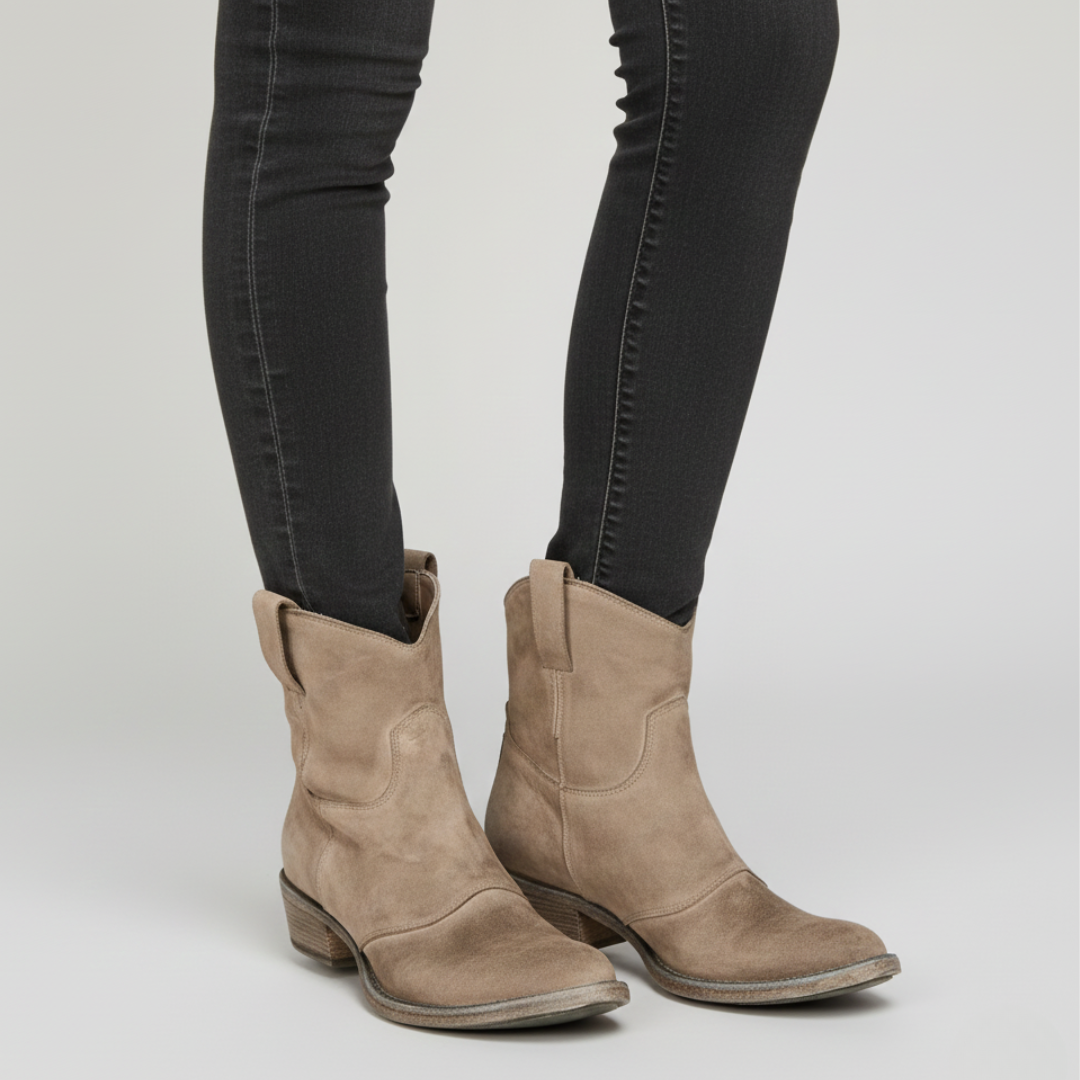 a pair of brown ankle boots featuring a pull-on design and low stacked heel